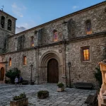 The Church of St. Jerome: Historical Legacy, Sacred Architecture, and Patron Saint 2 Stone facade and courtyard statue of Saint Jerome with friendly lion outside historic church
